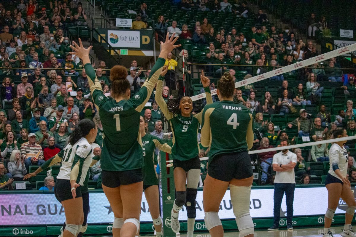 A volleyball team celebrates after scoring a point.
