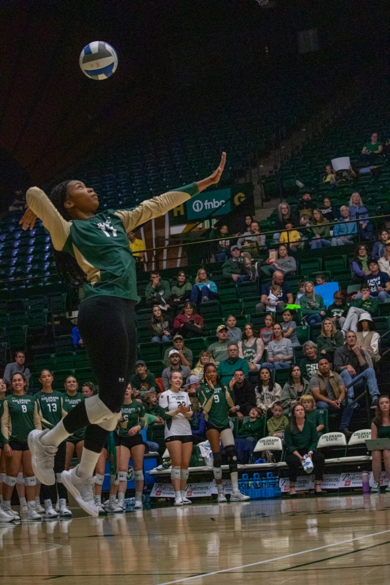 A volleyball player serves the ball.