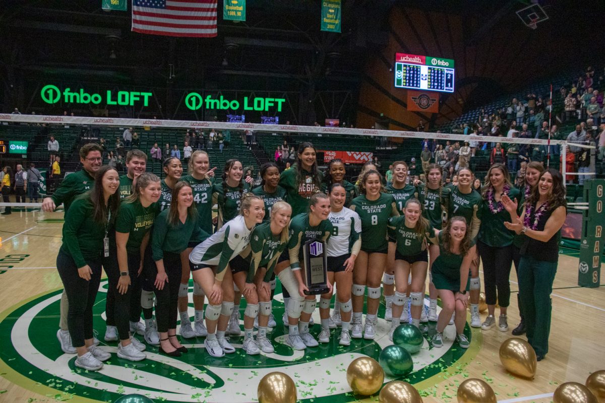 The volleyball team poses with a trophy.