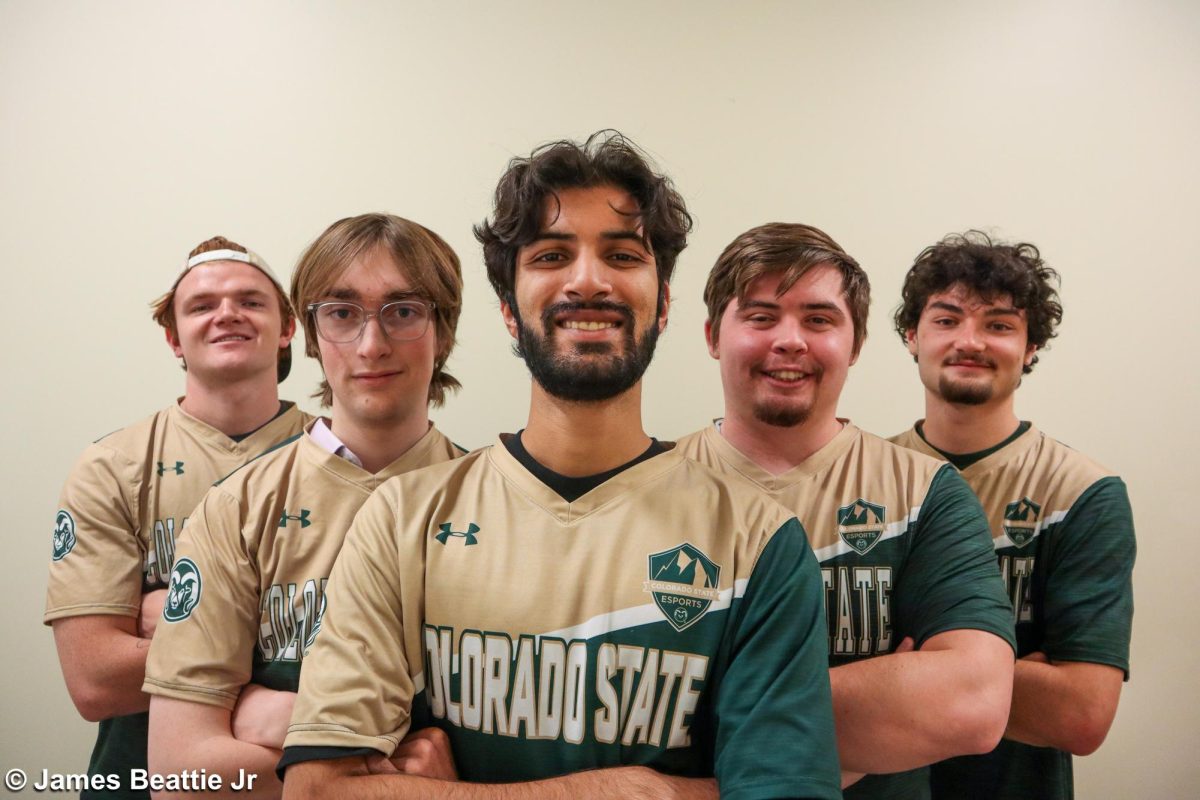 Five guys in gold and green uniforms smiling for a photo.