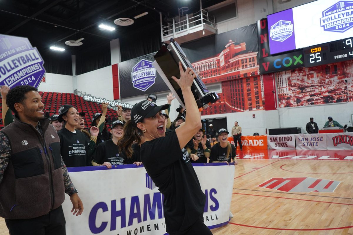 Coach Emily Kohan celebrating after team was just awarded Mountain West trophy for first place. The Rams beat San Jose State 3-1 Nov. 30. 