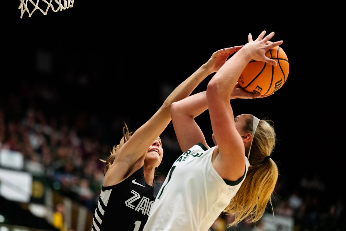 Two basketball players fight over a basketball.