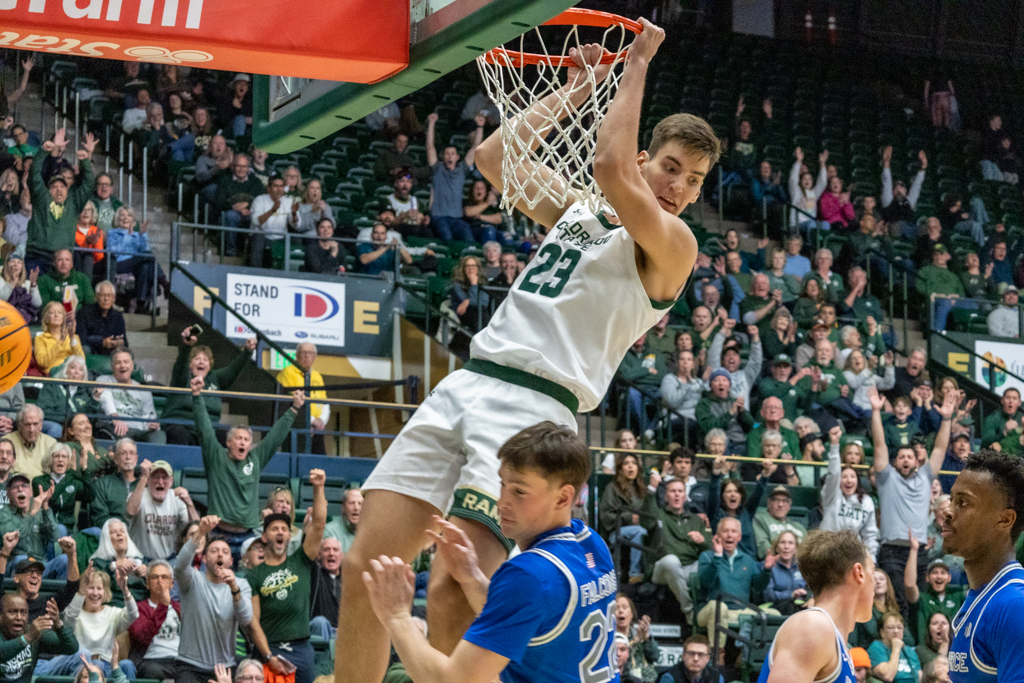 Nikola Djapa (23) swings from the hoop after dunking the ball Jan. 28. Djapa proved himself as an asset against the U.S. Air Force Academy, helping Colorado State University win 79-58.