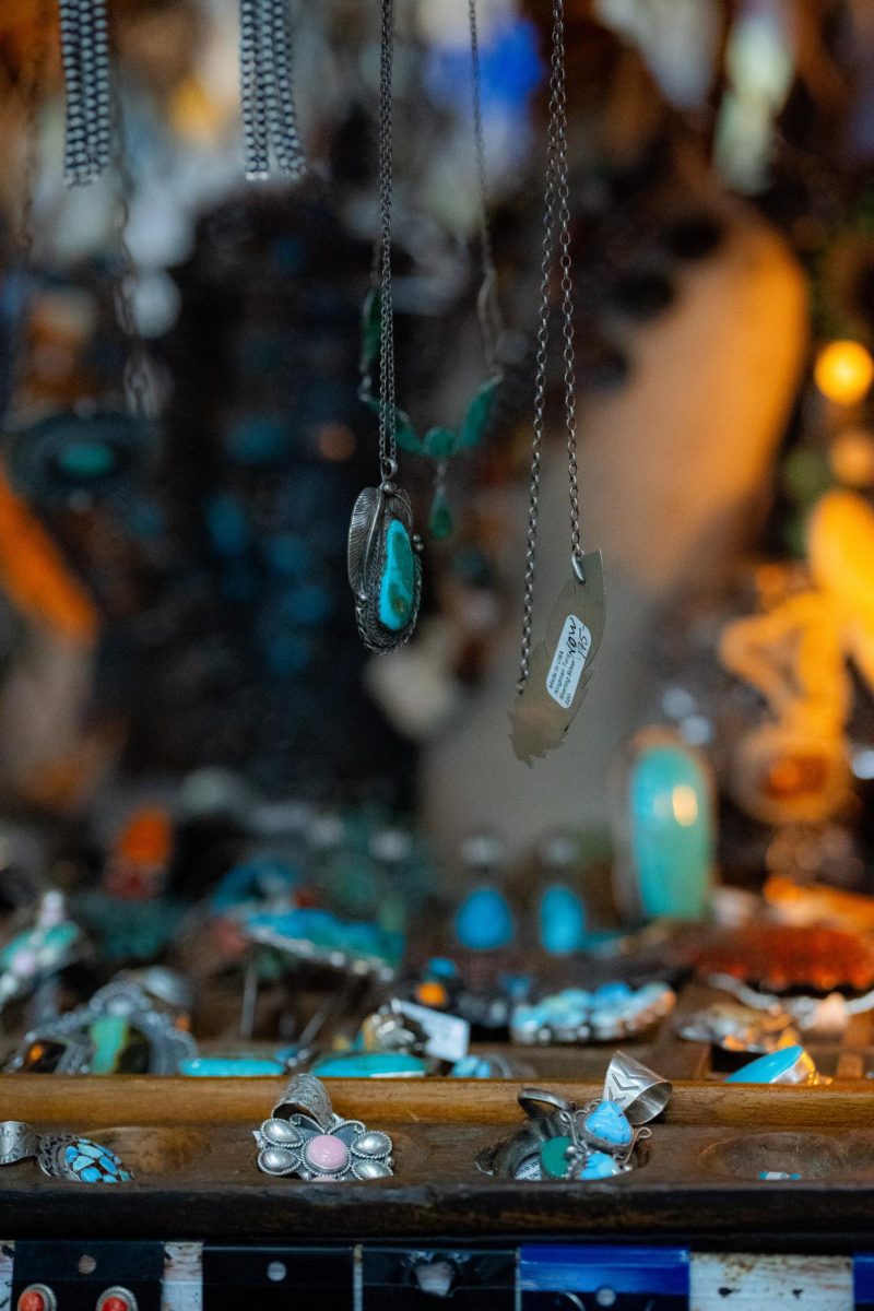 Turquoise jewelry hangs from a jewelry stand.