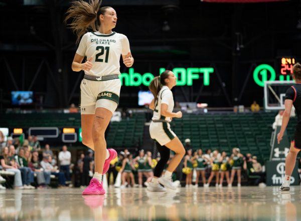 A player in white with pink shoes runs down the court