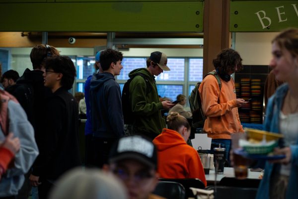 A group of students stand in line in a dining center