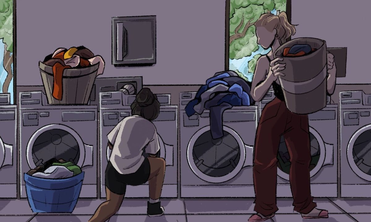 A student and a ram take their laundry out of the machines. On top of the second right-most laundry machine is a pile of clothes.