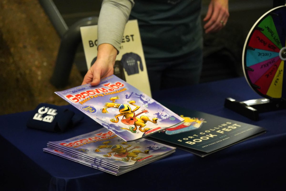 Person places a book called "Groovy Joe" down on a stack of books.