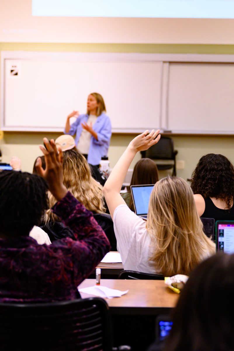 A student in Psychology of Human Sexuality raises their hand to answer a question asked by Professor Sara Garvey Feb. 7.