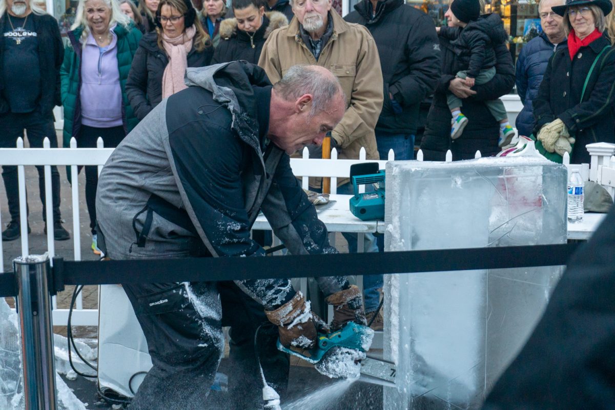 A person using a chainsaw to cut into ice.