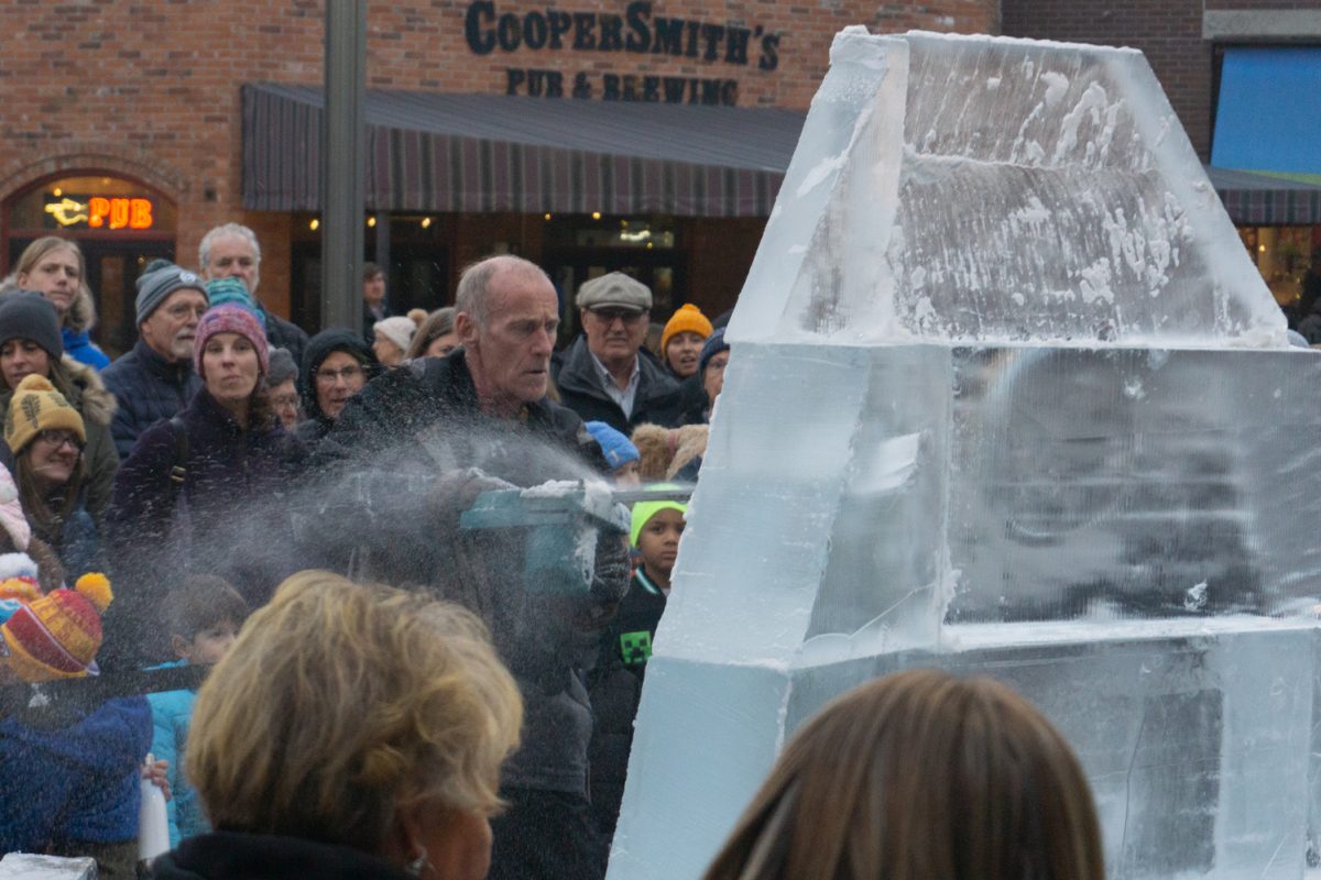 A person using a chainsaw to cut into ice.