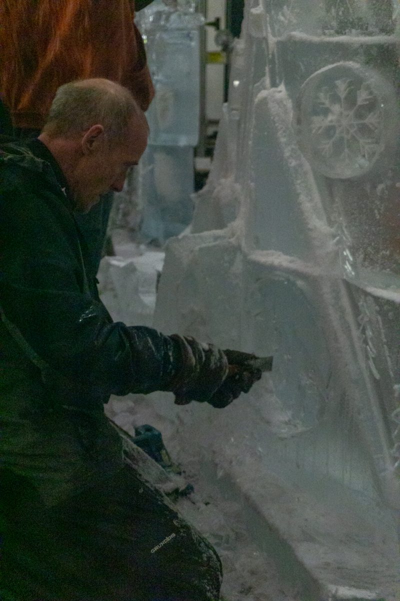 A person using a chainsaw to cut into ice.