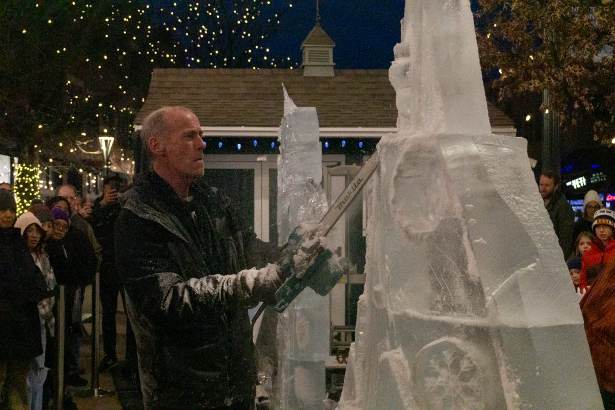 A person using a chainsaw to cut into ice.