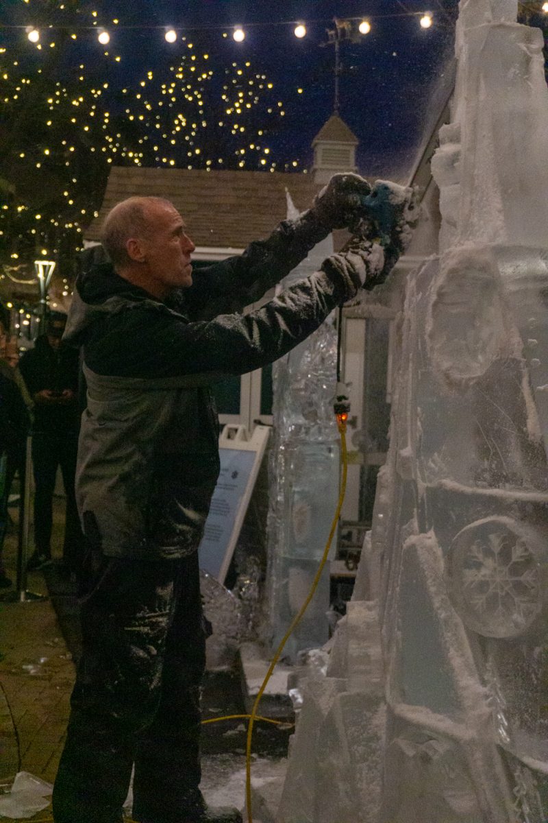 A person using a chainsaw to cut into ice.