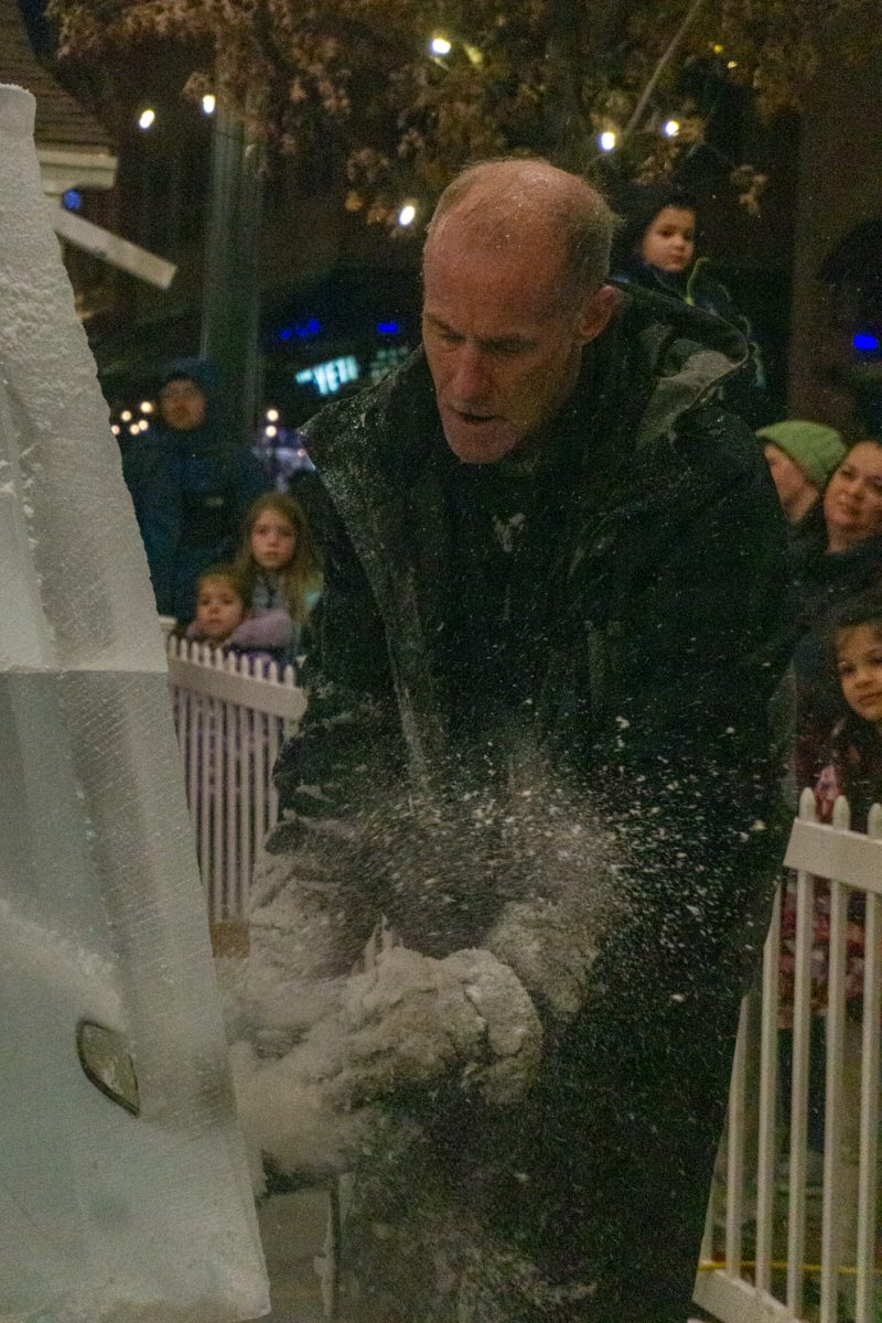 A person using a chainsaw to cut into ice.