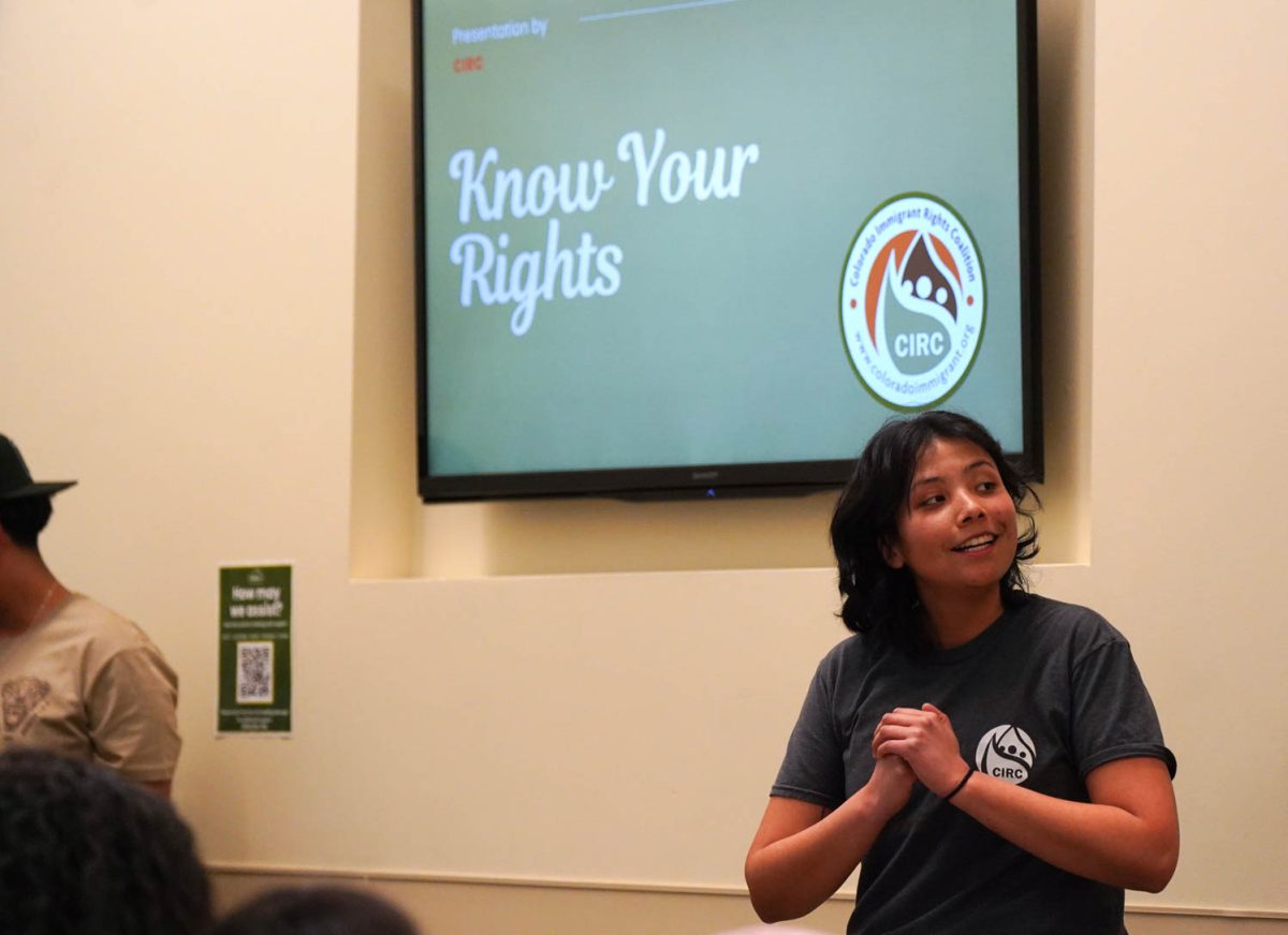 A woman stands in front of the "Know Your Rights" presentation as she presents.