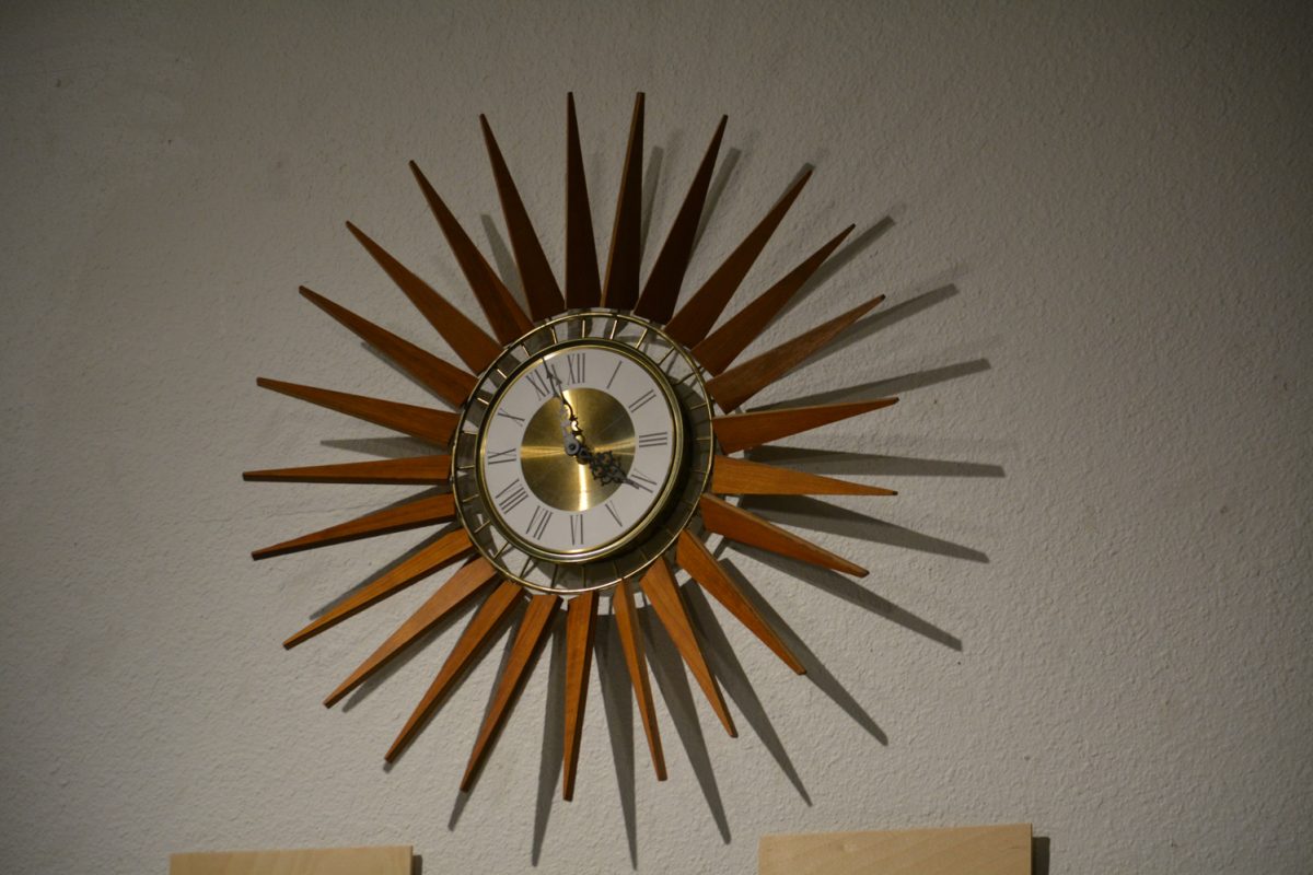 A clock with spikes coming out of the sides mounted on a wall