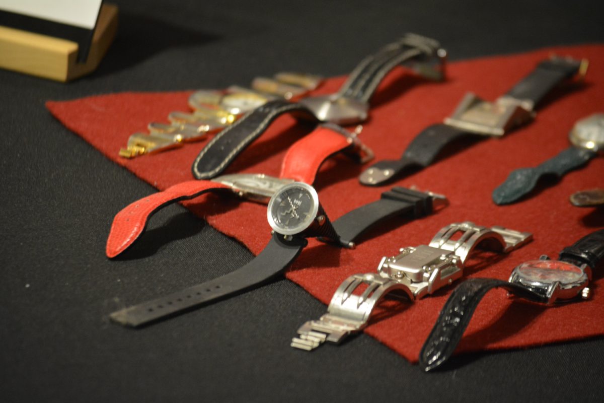 An array of different styles of watches on a black and red table