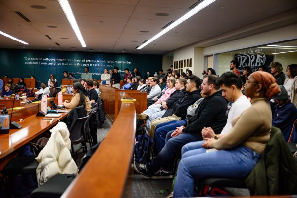 A room filled with people, both sitting and standing.