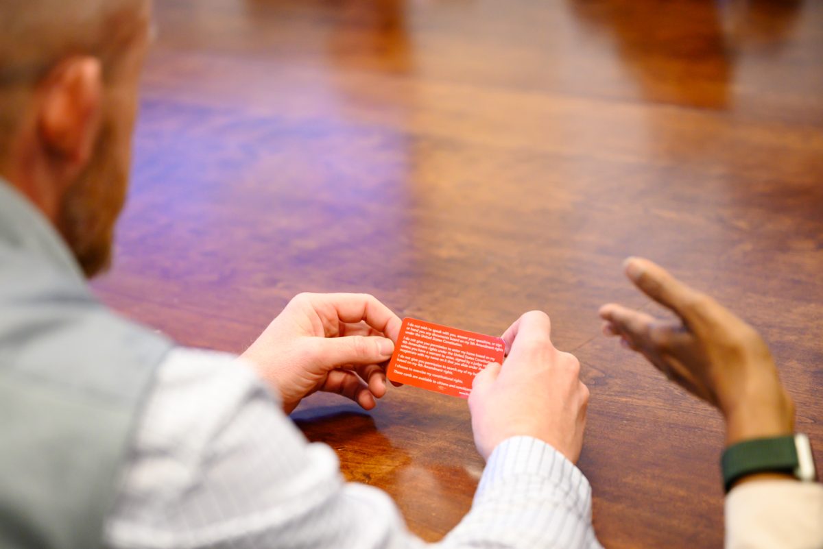 Chief of Staff Matt Tillman looks over a red card detailing what one should do in the event they are approached by ICE Feb. 20. Members of the People United gave him one of these cards and explained why they were important during a meeting with him in the Administration Building with Blanche Hughes and Marc Barker.