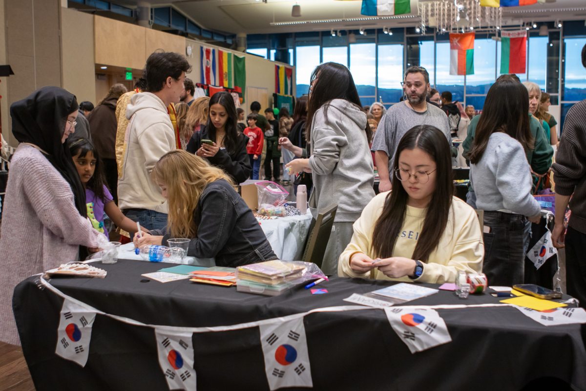 Students sit around a table that has South Korean flags dangling on the front of the space.