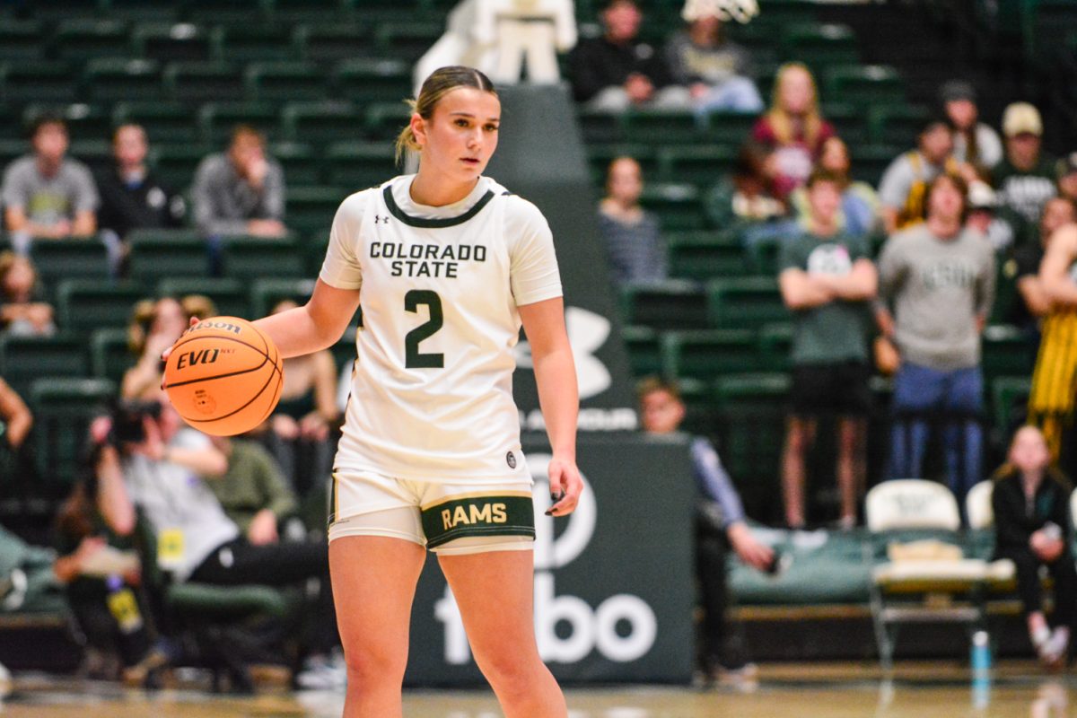 Player in green and white jersey dribbling the basketball