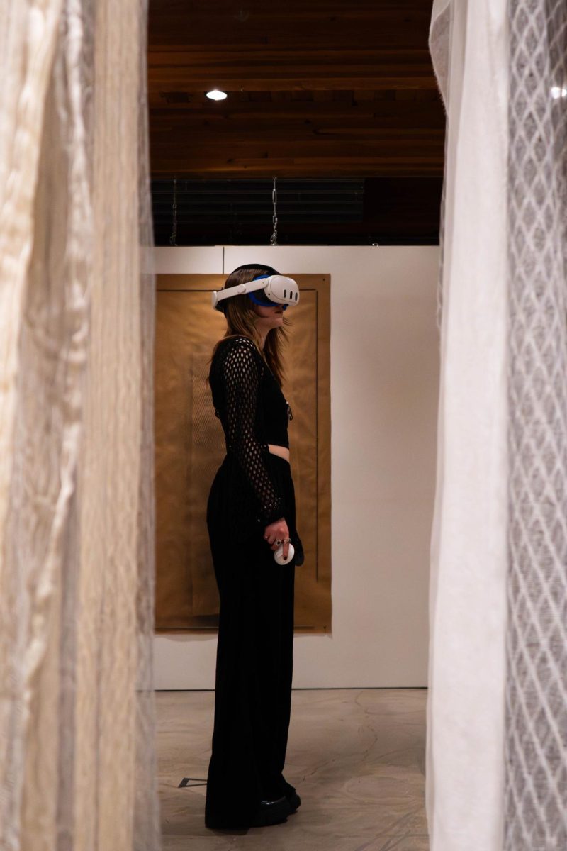 A woman stands facing right while wearing a VR headset