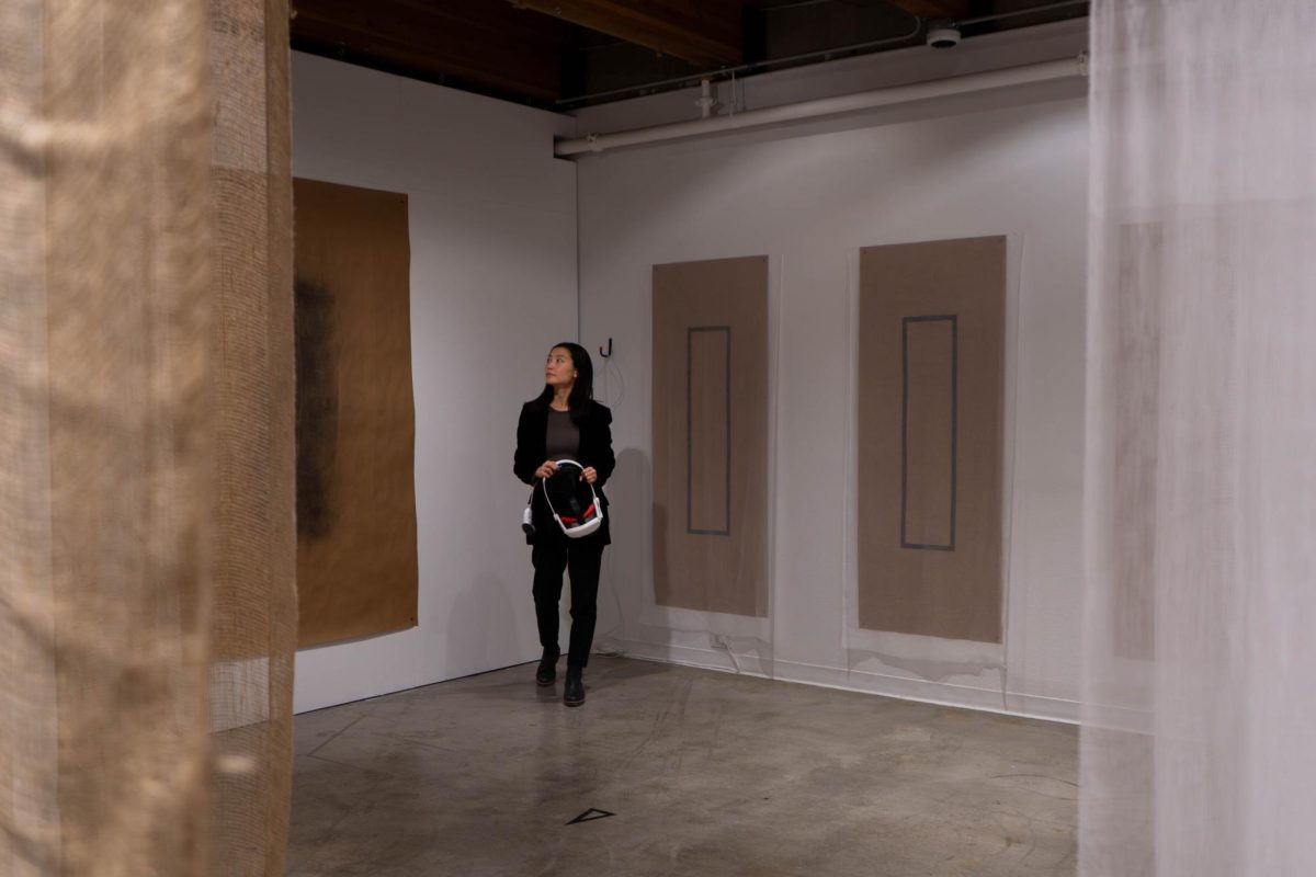 A woman holding a VR headset stands in an open room