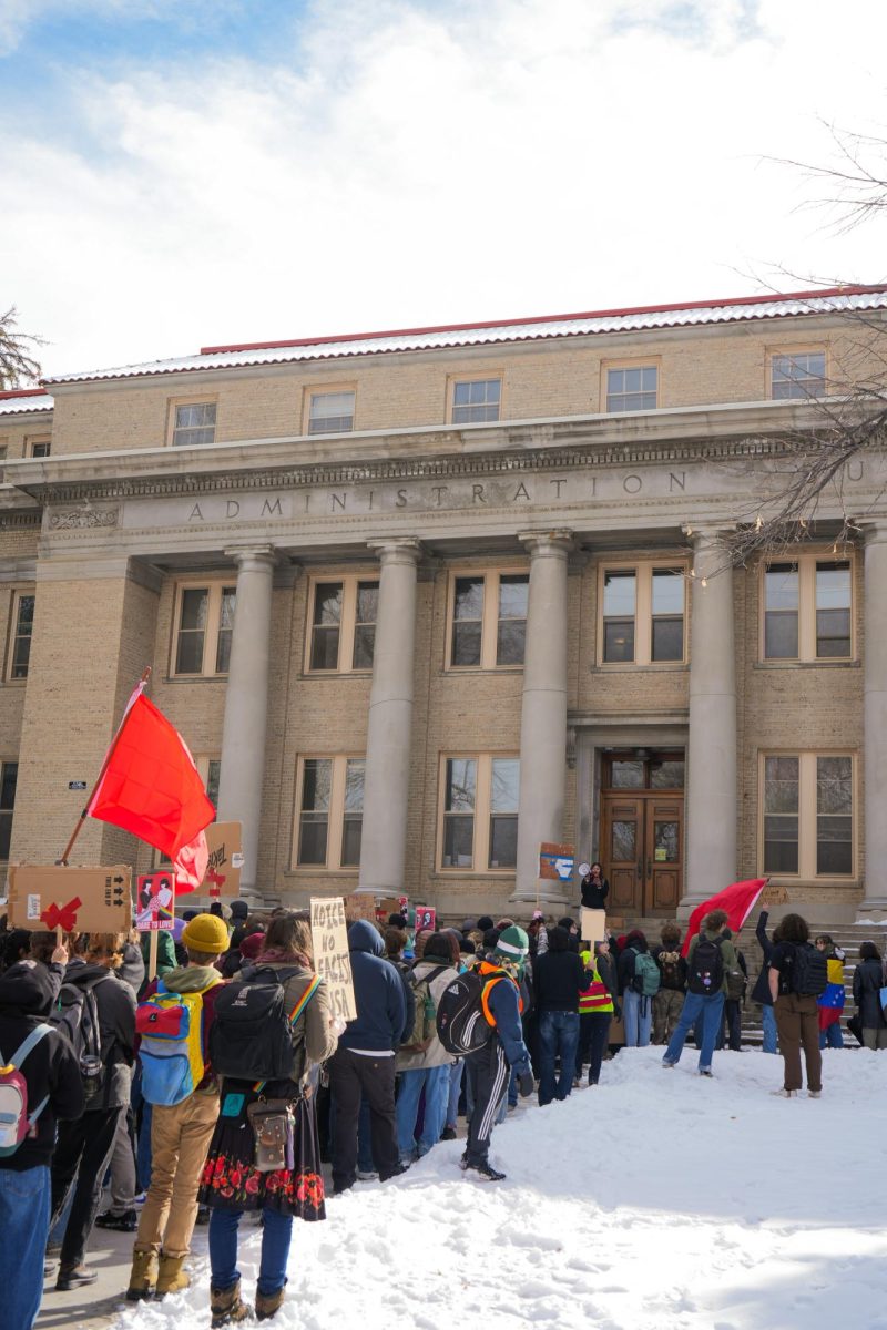 A crowd of protesters gathered in front of a snowy administration building at CSU.