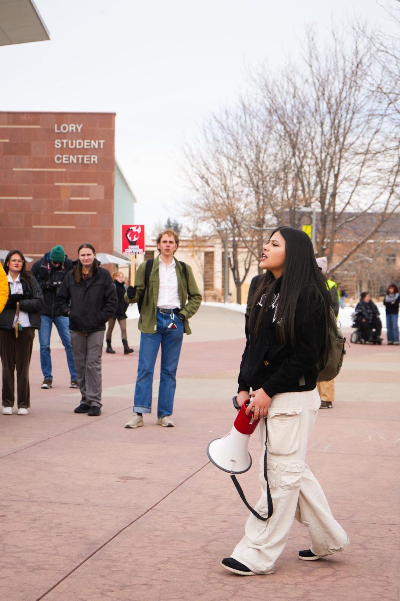 A student leads a chant in front of the Lory Student Center.