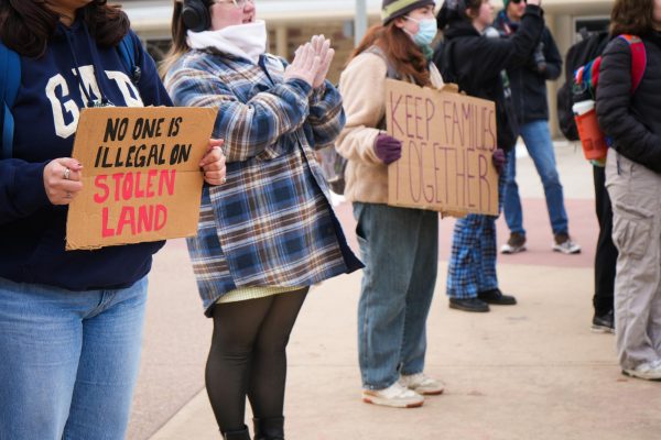 Students gathered to protest in front of the Lory Student Center hold signs that read, "No one is illegal on stolen land," and "Keep families together."