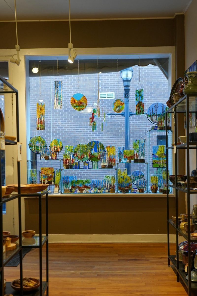 Stained glass on display in front of a window.