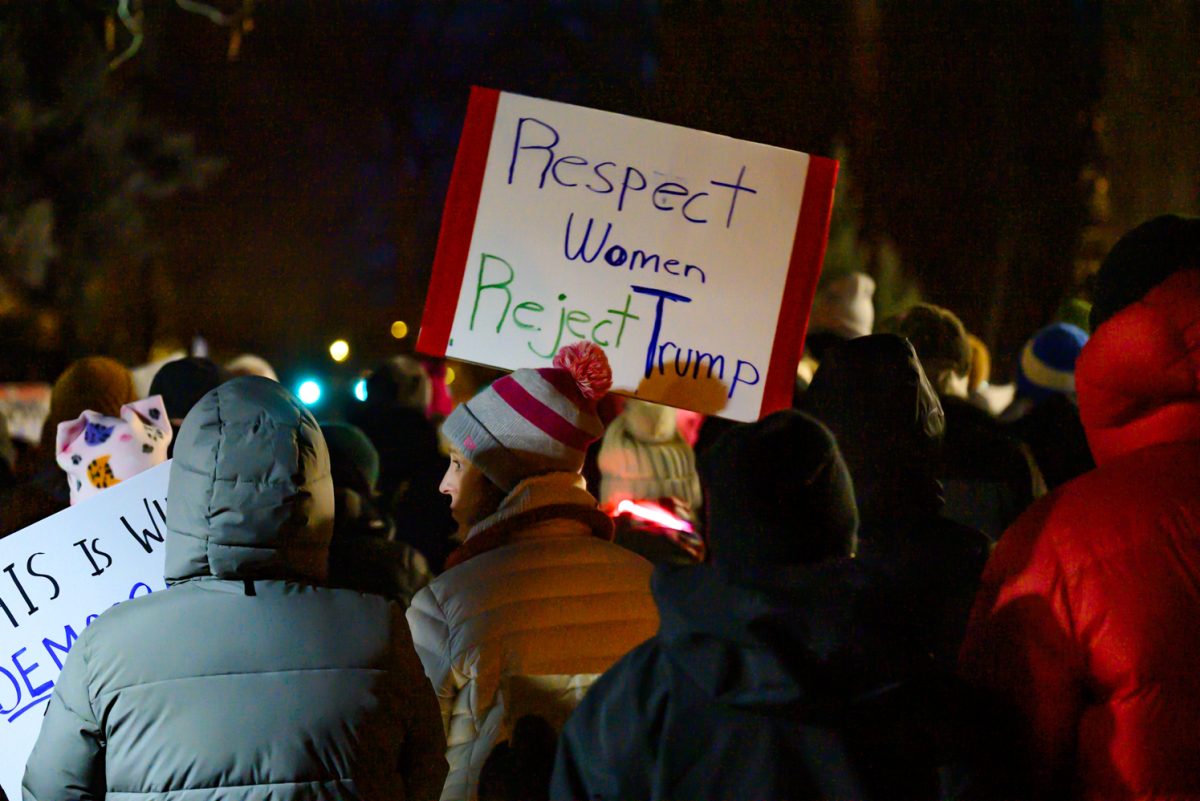 A woman carrying a sign saying, 'Respect Women Reject Trump,' in a crowd of protesters outside the Fort Collins Post Office March 4. Organized by the League of Women Voters, this protest was held to provide a space for community gathering during the President's address to Congress.