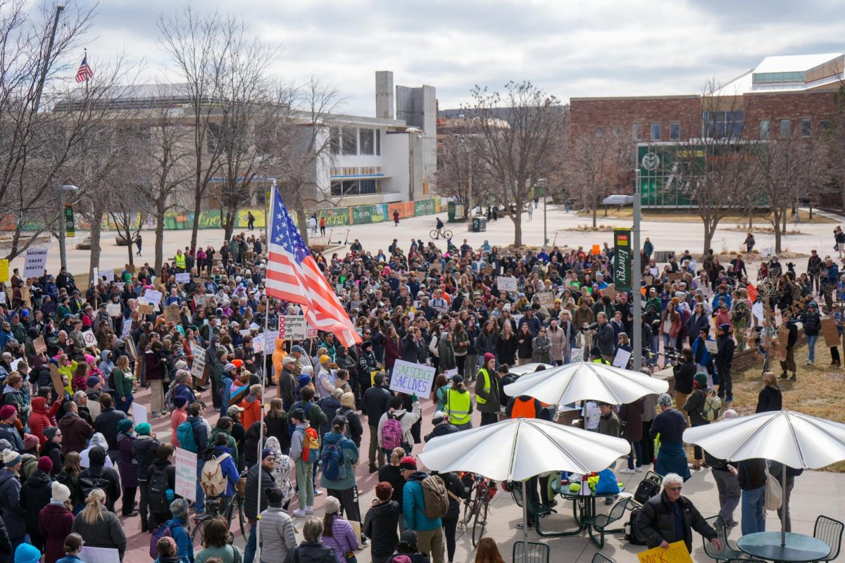 Photo of hundreds of students crowded around an area outside holding up posters.