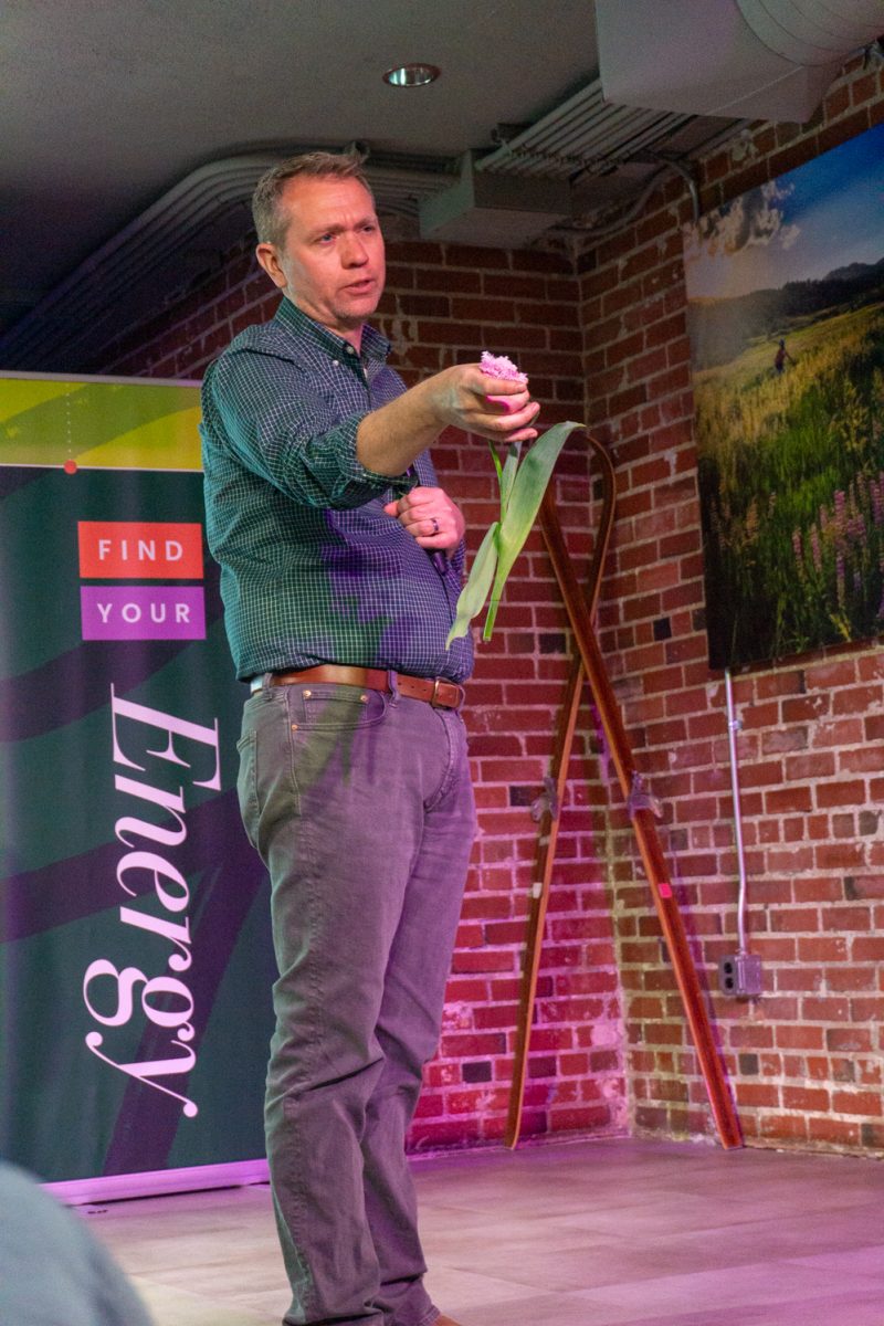 Chad Miller, Associate Professor at Colorado State University, shows a tulip to the audience during his talk, "Tiptoeing Through the Tulips: Exploring a Colorful History" at the Fort Collins Welcome Center March 12. In 1636, tulip prices rose quickly and then crashed the next year, also known as "Tulip Mania," Miller explained.