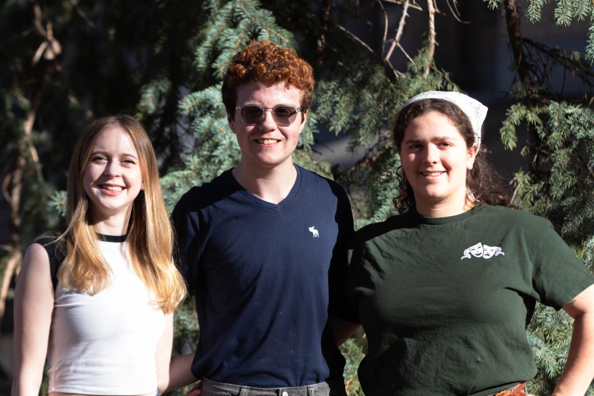 Three people smiling for a portrait.
