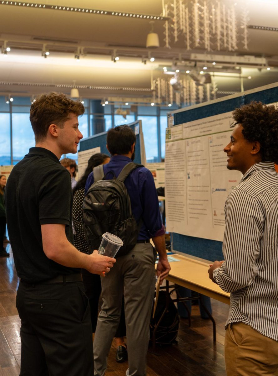 Gavin Gumpf, student presenter at the CURC Showcase, discusses his research with an attendee on April 17. 