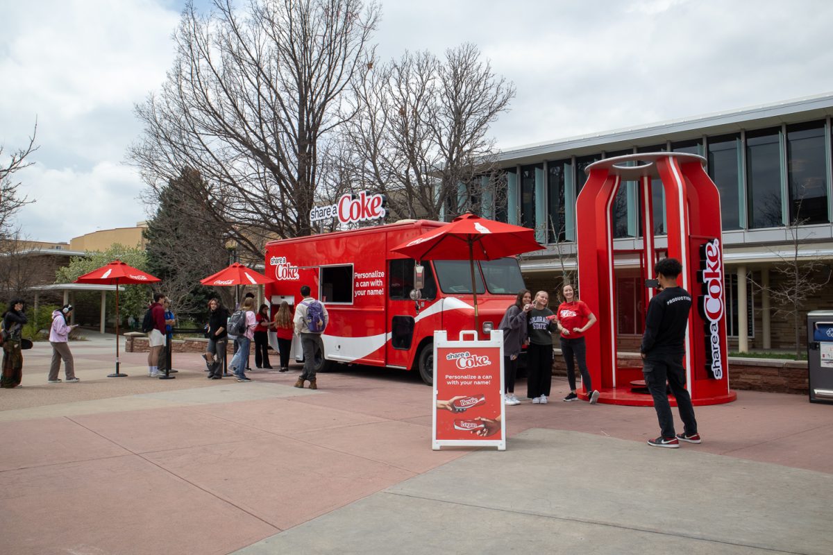 Anthony Tamayo, an employee at LNL Marketing Agency and host of the event, takes photos of Colorado State University students posing with their personalized Coke cans April 24. "My goal is to get as many cans out as possible with everybody having a smile on their faces," Tamayo said.