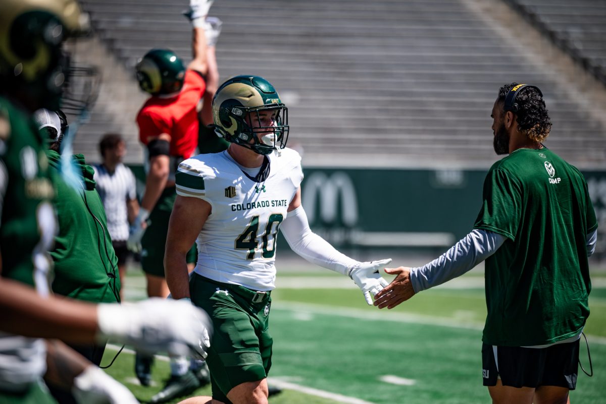 Colorado State University linebacker Owen Long (40) high-fives a coach while walking off the field during a spring football scrimmage April 26.