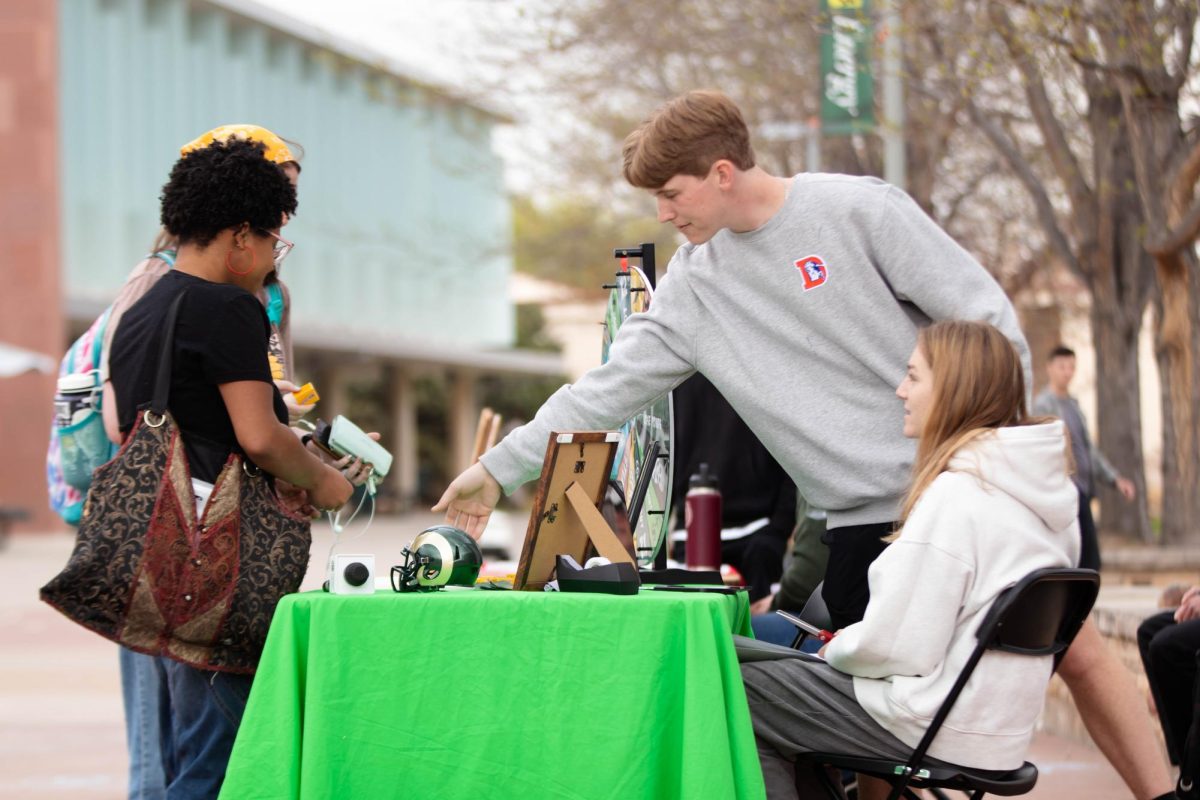 Colorado State University students Bella Walser and Mike Walsh advertise student organization CTV, at the Lory Student Center Plaza at Colorado State University in Fort Collins Colorado on April 24. "Sophmore me could never man this table by myself but no I'm more confident in it." Said Walser. Photo taken by Erica Pickering.