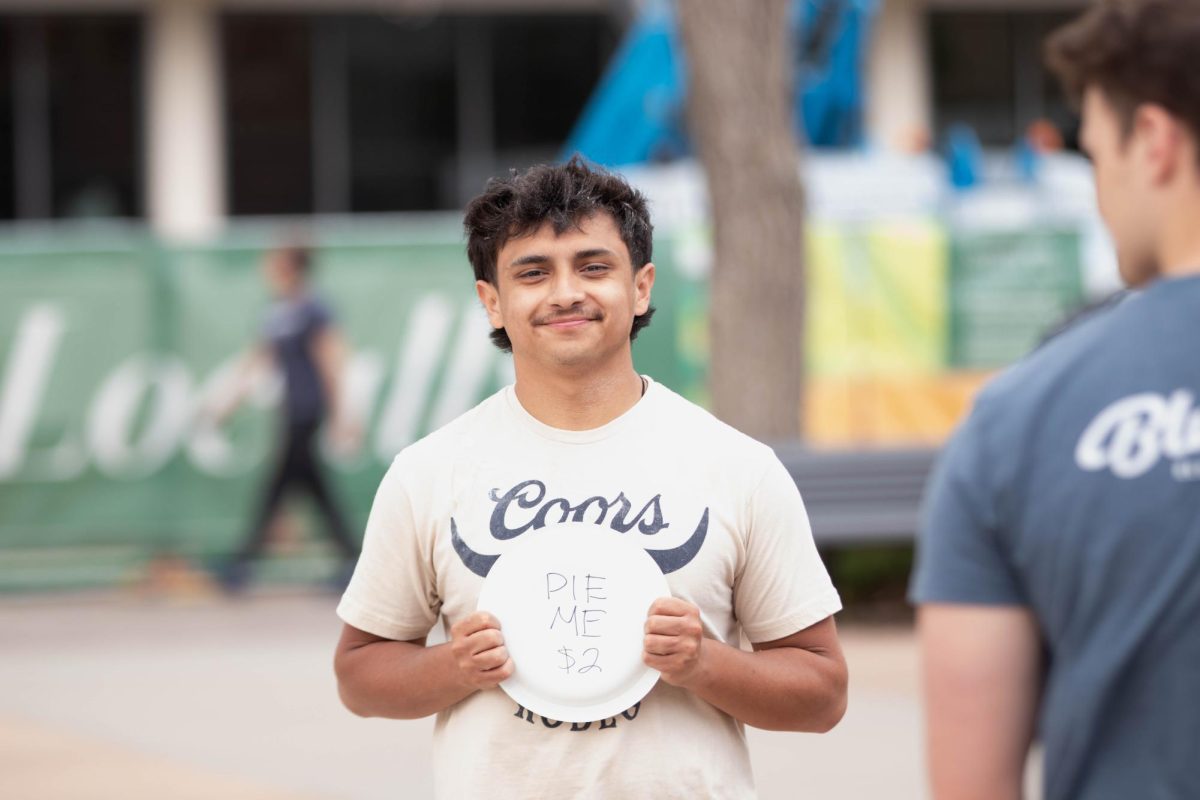 Sergio Strife advertises to be pied in the face for his fraternity, Delta Chi, to support cancer research on the Lory Student Center Plaza at Colorado State University April 27. 