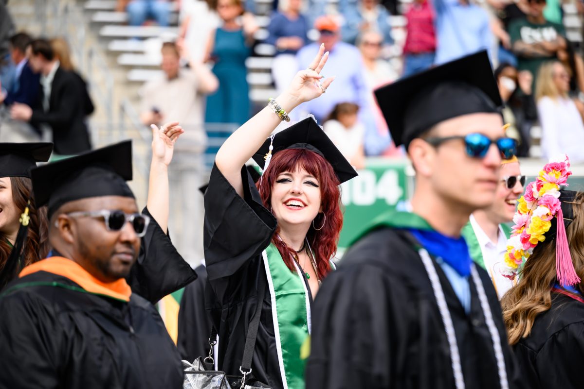 A procession of Colorado State University graduates walk onto the Canvas Stadium field for the first all-university Commencement Ceremony May 16.