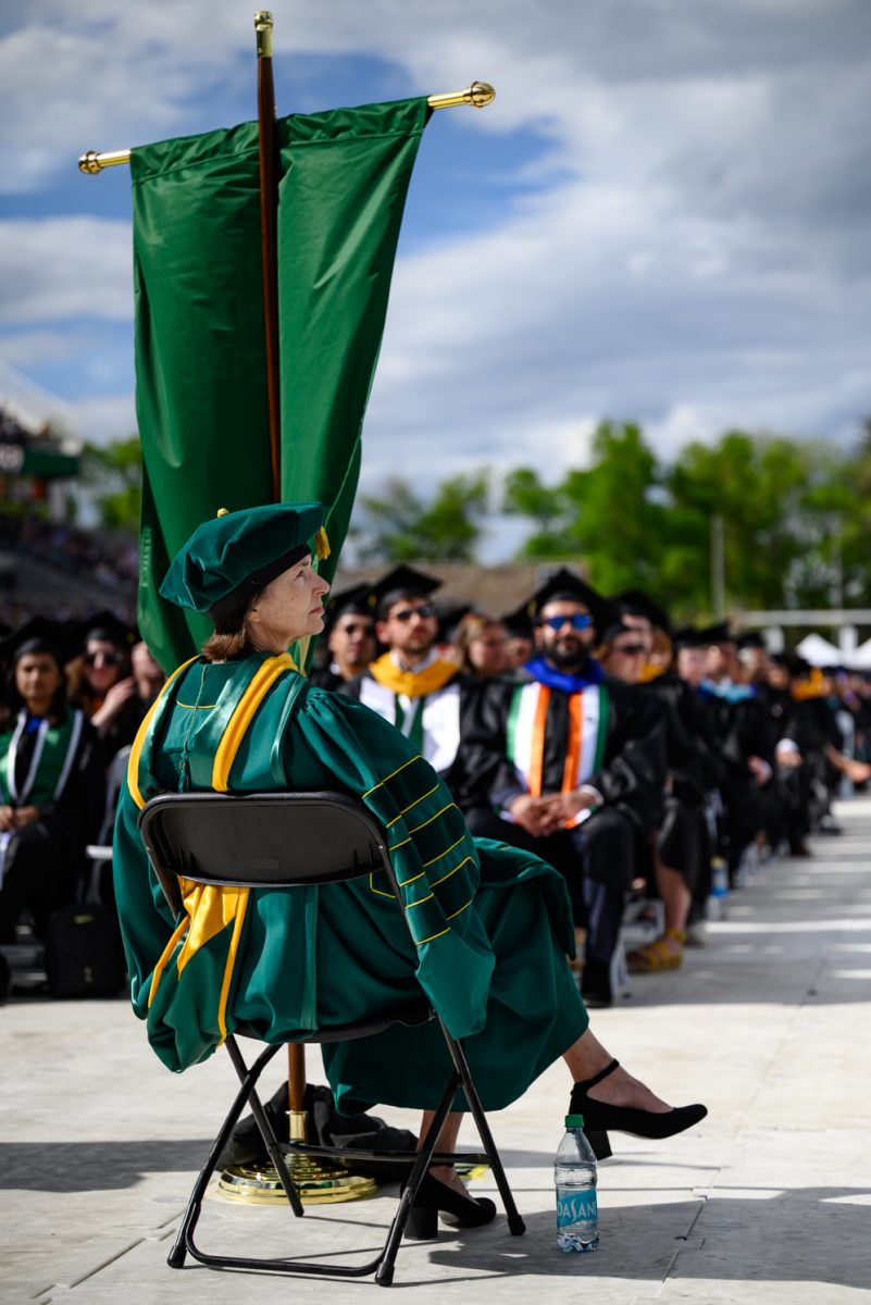 A processional leader sits in her chair and watches Colorado State University President Amy Parsons speak during commencement in Canvas Stadium May 16.