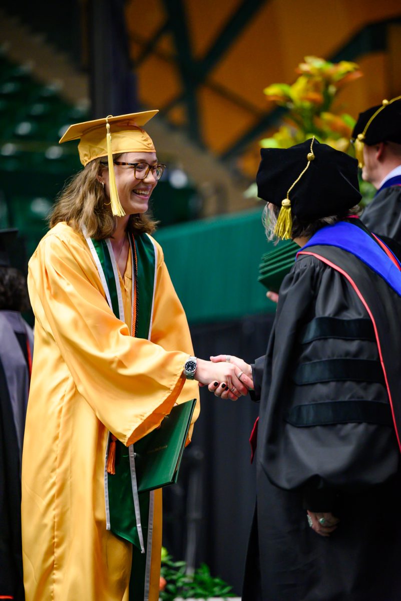 A graduating student shakes hands with faculty at the Agricultural Biology, Horticulture and Landscape Architecture and Soil and Crop Sciences recognition ceremony in Moby Arena May 18.