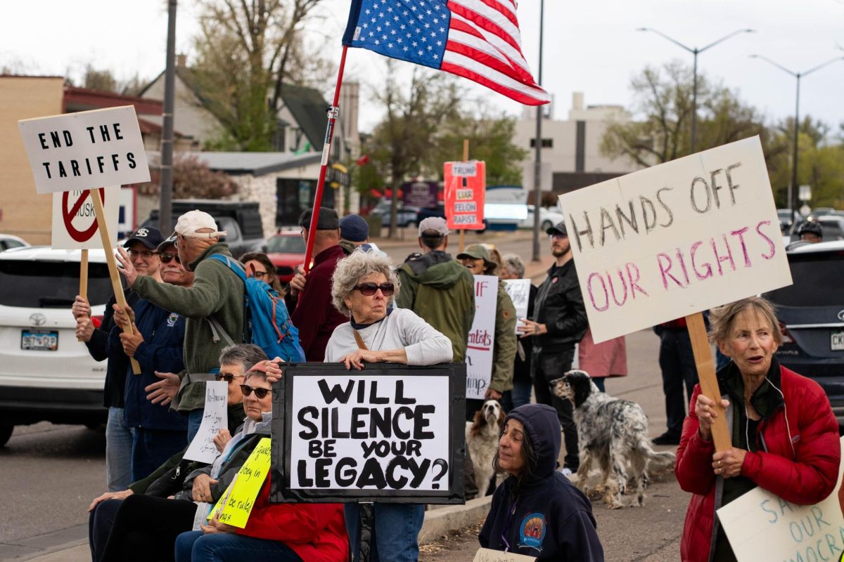 A group of protestors holds signs up to passing cars on the corner of College Ave. and Prospect road May 1.  Part of the May Day protests, a nation-wide movement protesting recent federal actions, Fort Collins residents lined College Ave.  