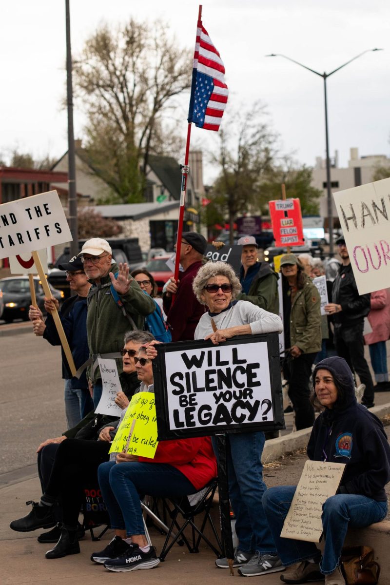 A group of protestors holds signs up to passing cars on the corner of College Ave. and Prospect road May 1.  Part of the May Day protests, a nation-wide movement protesting recent federal actions, Fort Collins residents lined College Ave.  