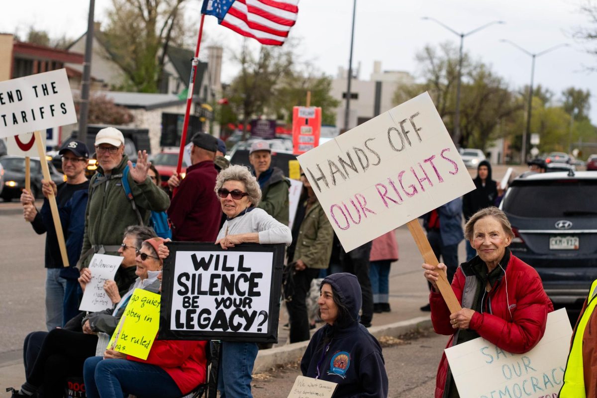 A group of protestors holds signs up to passing cars on the corner of College Ave. and Prospect road May 1.  Part of the May Day protests, a nation-wide movement protesting recent federal actions, Fort Collins residents lined College Ave.  