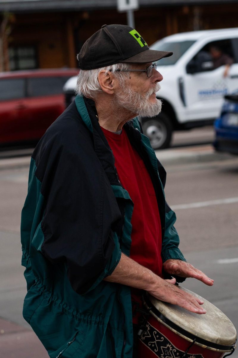 Jim Zdunek, a protestor part of the May Day protests May 1, plays a bongo drum for passing cars and protestors. Part of the May Day protests, a nation-wide movement protesting recent federal actions, Fort Collins residents lined College Ave.  