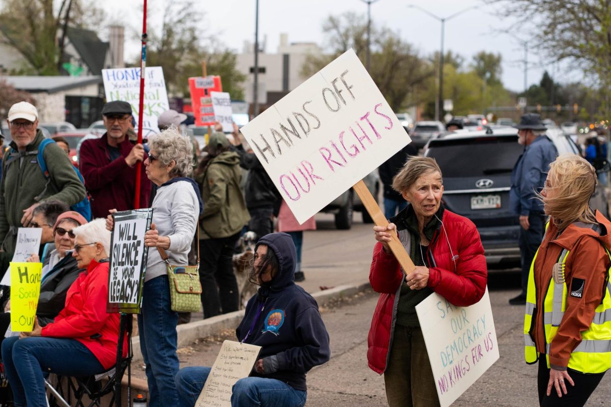 A group of protestors holds signs up to passing cars on the corner of College Ave. and Prospect road May 1.  Part of the May Day protests, a nation-wide movement protesting recent federal actions, Fort Collins residents lined College Ave.  