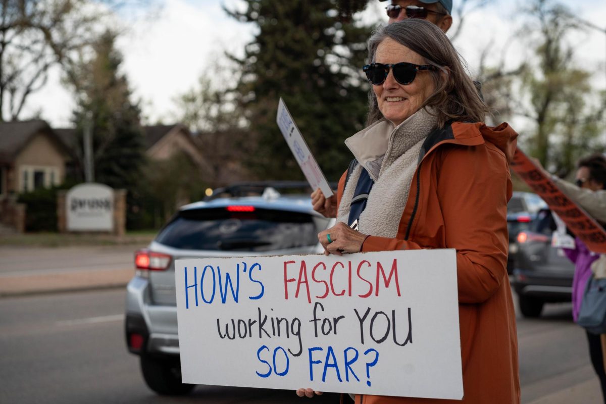 Jennifer Craig holds a sign as part of the May Day protests on College Ave.  Part of the May Day protests, a nation-wide movement protesting recent federal actions, Fort Collins residents lined College Ave.  